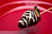 White and milk chocolate covered strawberry on a stick
